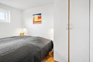 a bedroom with a bed and a white wall at G237-Lemvig-Syrenvej-37 in Lemvig