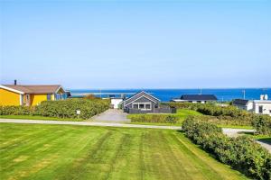 a view of a house with a lawn and the ocean at G237-Lemvig-Syrenvej-37 in Lemvig