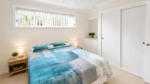 a bedroom with a large bed and a window at Sandy Feet in Wooli