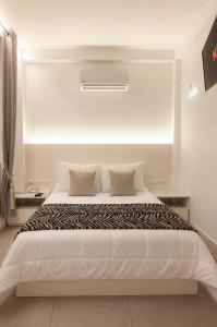a bedroom with a large white bed with pillows at Casa Patrones in Chiclayo