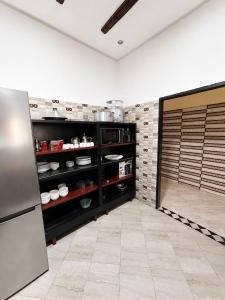 a kitchen with a refrigerator and a tile floor at Nzaha house in Douar Ahmed Ben Brahim
