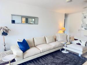 a living room with a white couch and blue pillows at Noosa Luxury Apartment in Noosa Heads