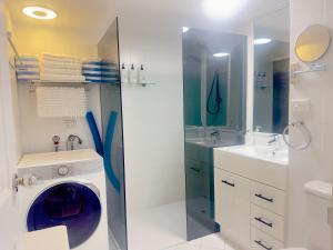 a bathroom with a washing machine and a sink at Noosa Luxury Apartment in Noosa Heads