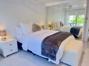 a bedroom with two beds and a large mirror at Noosa Luxury Apartment in Noosa Heads