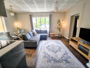 a living room with a couch and a tv at The Churchill Court in Woodstock