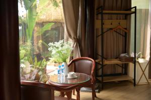 a table and a chair in a room with a window at Nọng Villa in Phan Thiet