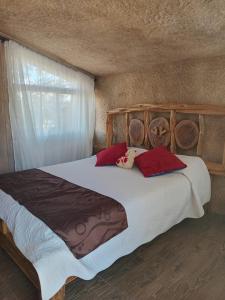 a bedroom with a large wooden bed with red pillows at Hotel la Union in Curití