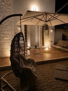 ein Zimmer mit einer Schaukel und einem Regenschirm in der Unterkunft Dimora morgese in Castellana Grotte