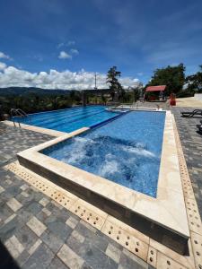 a large swimming pool with blue water at Hotel la Union in Curití