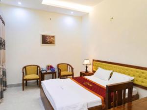 a hotel room with a bed and two chairs at LiLy Hotel Ninh Bình in Ninh Binh