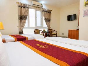 a hotel room with two beds and a television at LiLy Hotel Ninh Bình in Ninh Binh