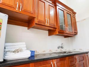 a kitchen with a sink and wooden cabinets at LiLy Hotel Ninh Bình in Ninh Binh +44 photos