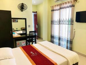 a bedroom with a bed and a desk and a mirror at LiLy Hotel Ninh Bình in Ninh Binh