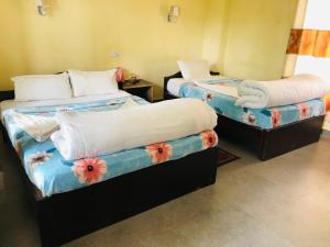 two beds in a room with flowers on them at silent park sauraha in Sauraha