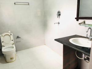 a bathroom with a toilet and a sink at silent park sauraha in Sauraha