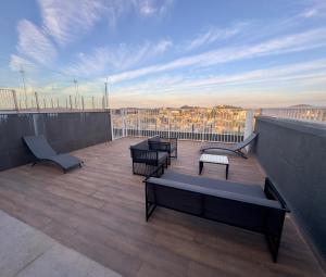 a balcony with benches and tables on a building at Aurora Studio no Centro in Barbacena