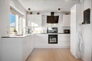 a white kitchen with white cabinets and a sink at 729-Thyboron-Vesterhavsgade-112 in Thyborøn