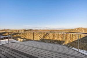 a wooden boardwalk with a view of the mountains at 729-Thyboron-Vesterhavsgade-112 in Thyborøn