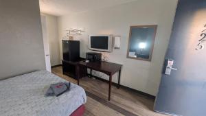 a room with a bed and a desk with a television at Queen Bed Hotel Room 225 in Amarillo