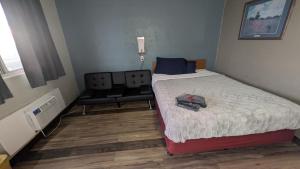 a small bedroom with a bed and a chair at Queen Bed Hotel Room 225 in Amarillo