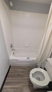 a bathroom with a toilet and a bath tub at Queen Bed Hotel Room 225 in Amarillo