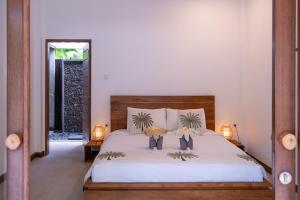 a bedroom with a bed with two people on it at Villa Adi in Amed