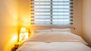 a bedroom with a white bed and a window at Geoje Blueberry Pet Pension in Geoje +10 photos