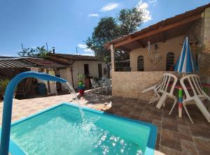 a pool with a water fountain in a yard at Hospedagem da Néli in Aparecida