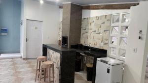a kitchen with a counter and stools in a room at Aquarela do Sertão in Piranhas