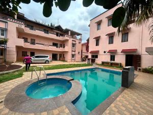 a swimming pool in front of a building at Breezevalley Residency in Yelagiri