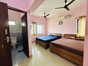 a bedroom with two beds and a bathroom at Breezevalley Residency in Yelagiri