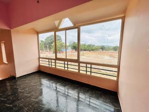 an empty room with a large window in a building at Breezevalley Residency in Yelagiri