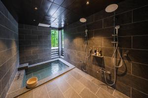 a large bathroom with a shower and a tub at Tanglin Maison Hakuba by Jade Villa in Hakuba