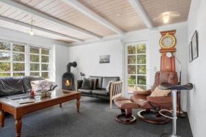 a living room with a couch and a clock on the wall at 0140-Romo-Kap-Farvel-7 in Høm