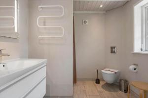 a white bathroom with a toilet and a sink at 0140-Romo-Kap-Farvel-7 in Høm +24 photos
