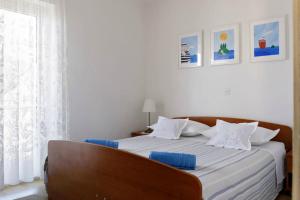 sypialnia z łóżkiem z niebieskimi poduszkami w obiekcie Apartments Margita w Hvarze