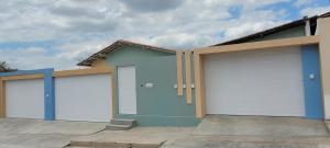 a row of four garages with white garage doors at Aquarela do Sertão in Piranhas