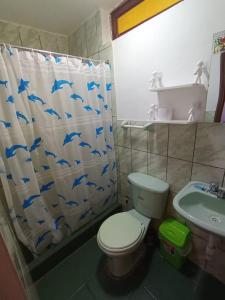 a bathroom with a shower curtain with a toilet and a sink at Hospedaje Hacienda Norabuena in Recuay +110 photos