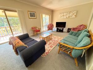 a living room with a couch and chairs and a television at Parkview Lodge - Bring your own linen. in South West Rocks