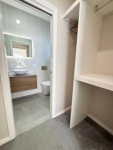 a bathroom with a sink and a toilet and a mirror at Parkview Lodge - Bring your own linen. in South West Rocks +18 photos
