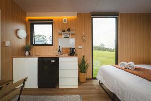 a bedroom with a bed and a kitchen with a counter at Two-Ki by Tiny Away in Rainbow Flat