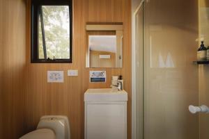 a bathroom with a toilet and a sink and a mirror at Two-Ki by Tiny Away in Rainbow Flat