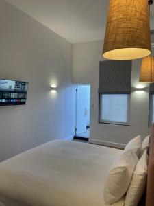 a bedroom with a large white bed and a window at The Porcupine Place in Sale