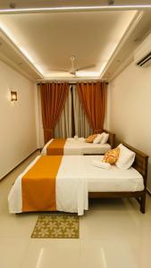 a bedroom with two beds and a window at Harbour Front Villa in Trincomalee