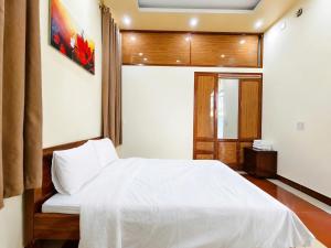 a bedroom with a white bed in a room at The Mellow House Nhật Lệ in Dong Hoi