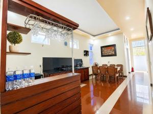a kitchen and dining room with a bar and chairs at The Mellow House Nhật Lệ in Dong Hoi