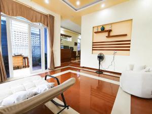 a living room with a white couch and a chair at The Mellow House Nhật Lệ in Dong Hoi