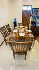 a wooden table with plates of food on it at Harbour Front Villa in Trincomalee +30 photos