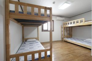 a room with two bunk beds and a window at Friends of Loft in Tongyeong