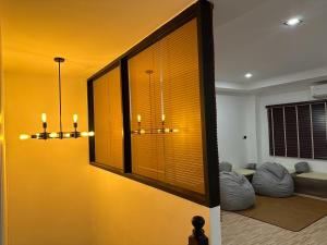 a living room with yellow walls and a large window at 9 mins to BTS Queen Bed Private Room - Share Bath in Amphoe Phra Khanong